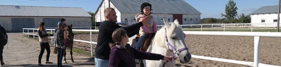 dziewczynka w kasku jeżdżąca na koniu