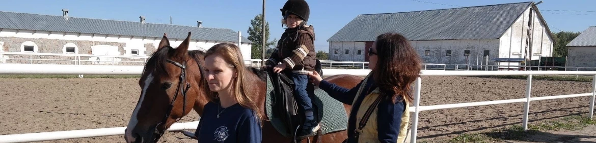 dziewczynka prowadzona na koniu